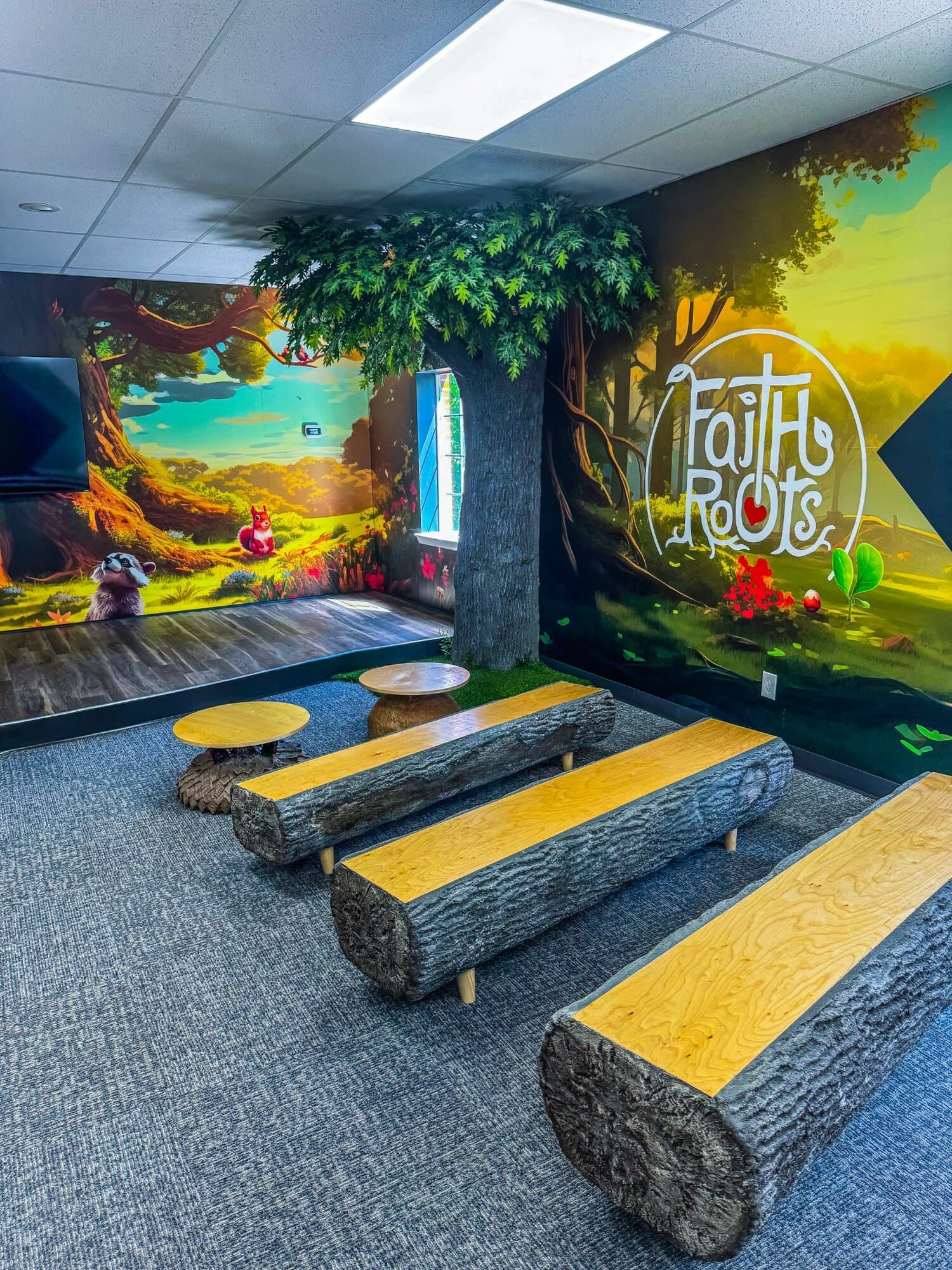 Faith Roots children’s ministry room with custom tree and log benches